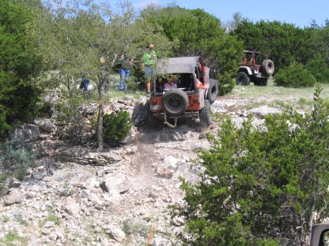 1996 Ford Bronco - Jeeps navigating a challenging rocky incline during an off-road excursion.