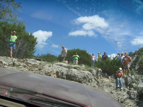 1996 Ford Bronco - A group of people observe the terrain from a rocky outcrop on a sunny day.