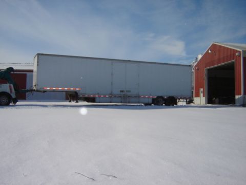 1992 Ford Bronco - A white semi-trailer is parked beside a red barn on a snowy day.