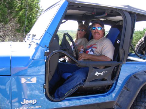 1996 Ford Bronco - Two people are inside a blue Jeep Wrangler, enjoying an outdoor drive.