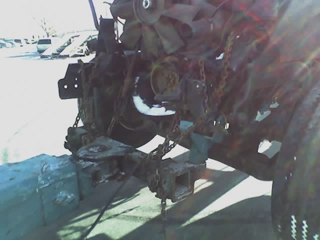 close-up of rusty vehicle engine and frame with chains attached