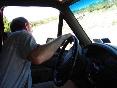1996 Ford Bronco - A man drives his truck on a dirt road, with another SUV visible in the distance.