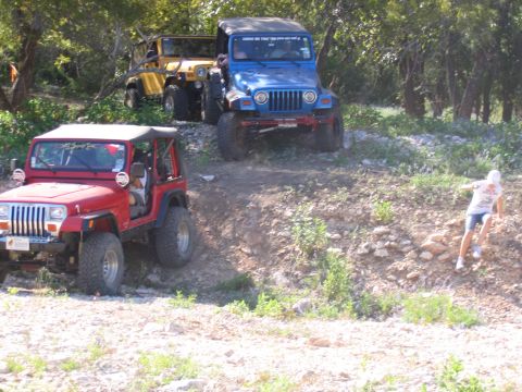 1996 Ford Bronco - Multiple Jeep Wranglers navigate a rocky incline during an off-road excursion.