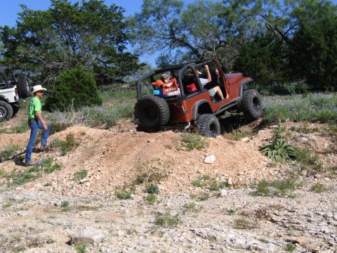 1996 Ford Bronco - Two Jeeps navigate a rocky, off-road trail under a clear blue sky.
