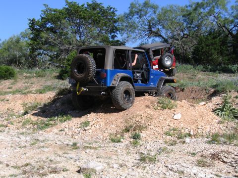 1996 Ford Bronco - Two Jeep Wranglers navigate a challenging off-road course on a sunny day.