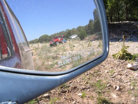 1996 Ford Bronco - Multiple off-road vehicles are seen in the reflection of a side mirror on a sunny day.