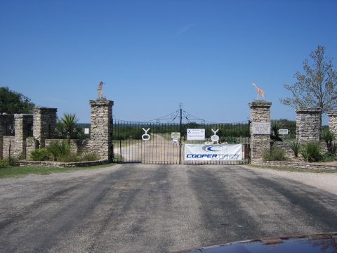 1996 Ford Bronco - Entrance gate to a property, stone pillars, metalwork, and signage.