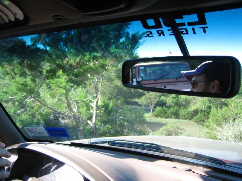 1996 Ford Bronco - View from inside a vehicle, showing the dashboard and windshield, with another vehicle visible in the rearview mirror.