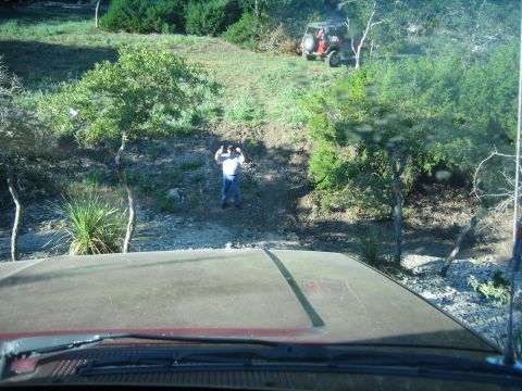 1996 Ford Bronco - View from inside a vehicle shows a person and a red Jeep in a wooded, hilly area.