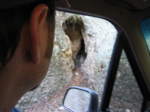 1996 Ford Bronco - View from inside a vehicle looking towards a cave entrance, with a side mirror visible.