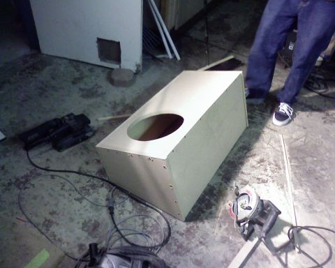 1995 Ford Bronco - An unfinished speaker box sits on a concrete floor surrounded by tools, including a circular saw and a power drill.