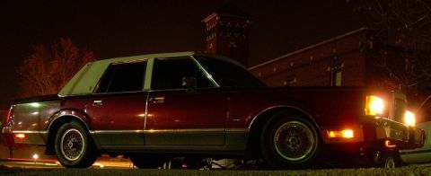 1989 Lincoln Town Car - This 1989 Lincoln Town Car is captured in a three-quarter front view at night, highlighting its classic design.