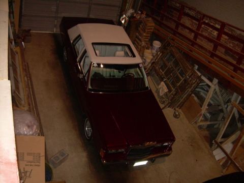1989 Lincoln Town Car - A maroon 1989 Lincoln Town Car with a white vinyl top is parked inside a garage.