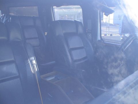 1993 Ford C-350 (Centurion Conversions) - The interior of a van shows plush leather seating and a wooden center console.
