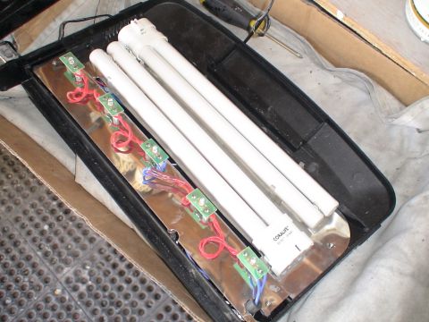 1993 Ford C-350 (Centurion Conversions) - Disassembled fluorescent light fixture showing internal wiring, circuit boards, and tubes.