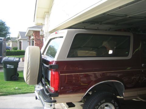 1996 Ford Bronco - Rear view of a 1996 Ford Bronco, showing its distinctive two-tone paint and spare tire carrier.