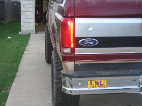 1996 Ford Bronco - Rear view of a maroon Ford truck with a chrome bumper and LSU Alumni sticker.