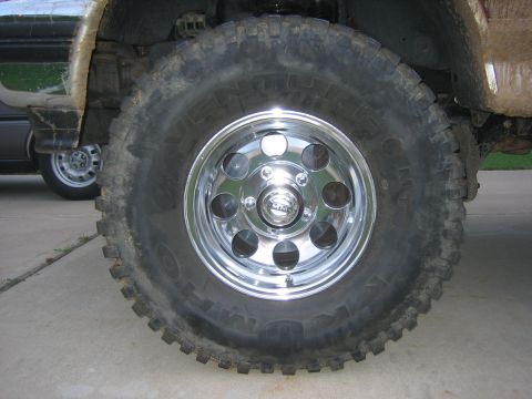 1996 Ford Bronco - This photo shows a vehicle's wheel and tire, with another vehicle in the background.