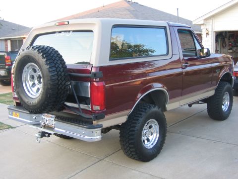 1996 Ford Bronco - This Ford Bronco is parked in a driveway with a house and garage in the background.