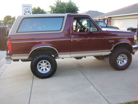 1996 Ford Bronco - Maroon 1996 Ford Bronco with tan roof and trim, parked in a driveway.