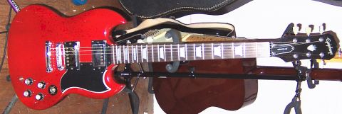 1978 Ford Bronco - A red Epiphone electric guitar is displayed on a stand, with another guitar visible in the background.