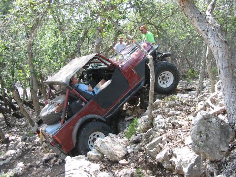 1996 Ford Bronco - Off-road vehicle navigating a challenging, rocky path with onlookers.