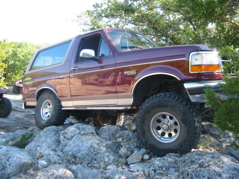 1996 Ford Bronco - This 1996 Ford Bronco is shown navigating a rocky trail, highlighting its off-road capabilities.