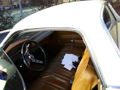 1970 Ford Ranchero - The interior of the vehicle shows brown vinyl seats and a dashboard with a steering wheel.