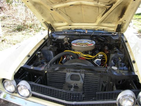 1970 Ford Ranchero - The engine bay of a 1970 Ford Ranchero is visible, a chrome air cleaner and yellow spark plug wires.
