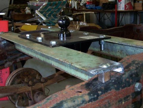 1992 Lincoln Custom - This photo shows the installation of a fifth wheel hitch onto the frame of a truck, with visible leaf springs and a wheel.