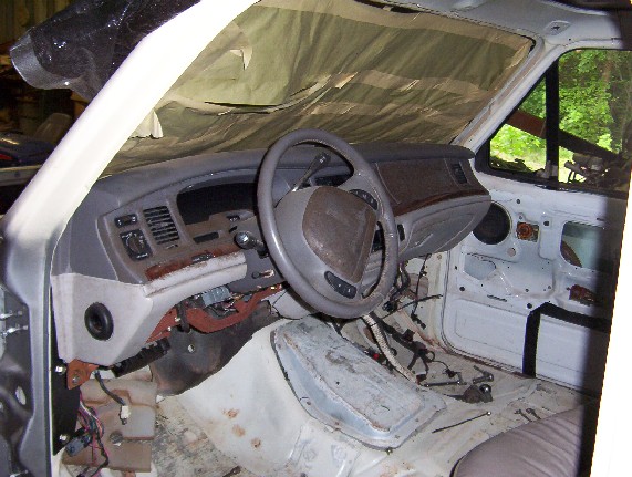 Stripped car interior mid-restoration, woodgrain dash, seats removed