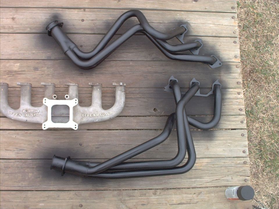 Offenhauser intake manifold and two sets of exhaust headers on wooden planks