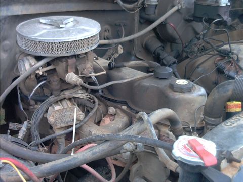 1985 Ford Bronco - Close-up view of an engine bay, focusing on the carburetor and associated parts.