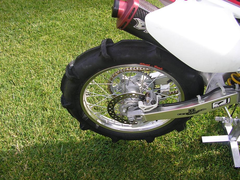Dirt bike rear wheel with Skat-Trak paddle sand tire, disc brake and aluminum swingarm