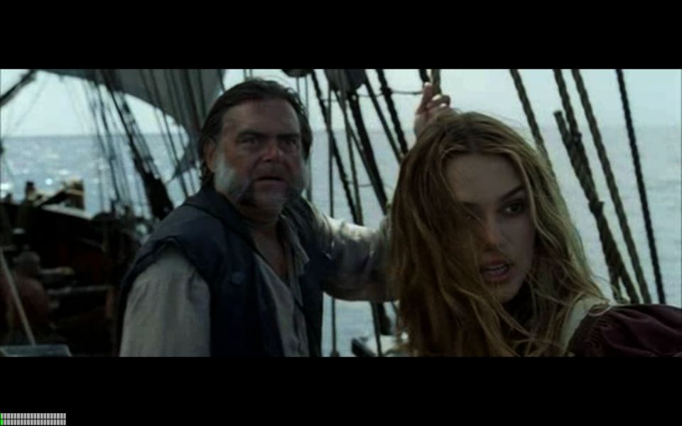 Man and woman on a ship deck with sails and rigging in the background