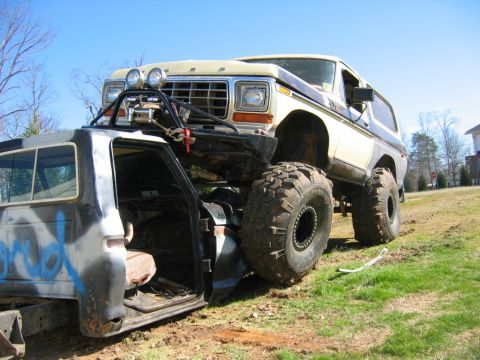 1992 Ford Mustang - A heavily modified Ford Bronco is perched atop another custom truck, extreme off-road modifications.