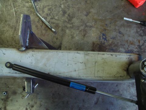 1996 Ford Bronco - A metal bracket and gas strut are shown on a workbench.
