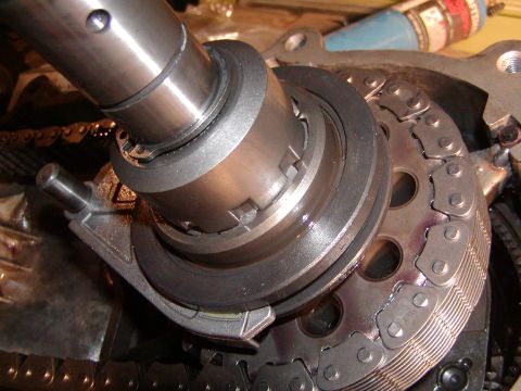 1991 Ford Bronco - A close-up view of internal engine timing chain and gears, with a metal shaft engaged.