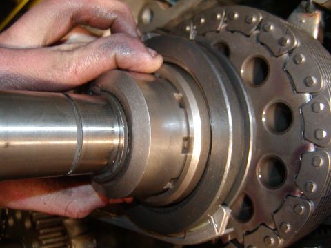 1991 Ford Bronco - Close-up of a hand adjusting engine timing components, including a chain and gears.