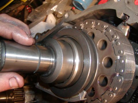 1991 Ford Bronco - Close-up view of an engine's timing chain and camshaft components, with a hand present.