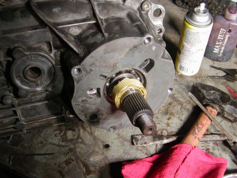 1991 Ford Bronco - Close-up of a transmission output shaft assembly, with tools and lubricants visible on the workbench.