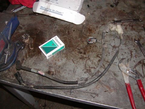 1991 Ford Bronco - Workbench with automotive wiring, cigarettes, and tools.