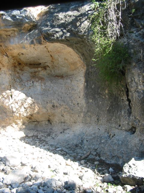 1996 Ford Bronco - A natural rock formation with an overhang, showing texture and vegetation growth on the right side.