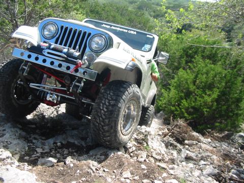 1996 Ford Bronco - White Jeep CJ-7 navigates a rocky trail during an off-road excursion.