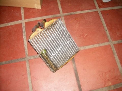 1989 Lincoln Town Car - A detached heater core is shown on a tiled surface, likely removed for repair or replacement.