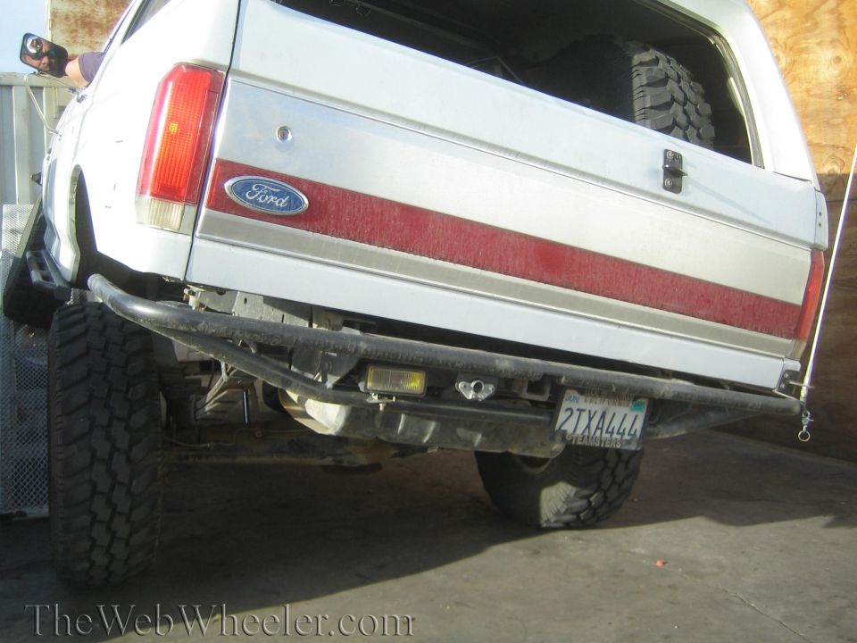 Rear tailgate of a white Ford Bronco with red stripe and California plate 2TXA444