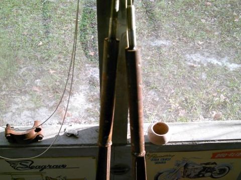 1986 Ford Bronco - A view through a window reveals two metal rods and a sign depicting a motorcycle.