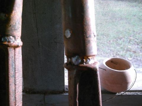 1986 Ford Bronco - Rusted metal posts with welds are shown in detail, with a small pot nearby.
