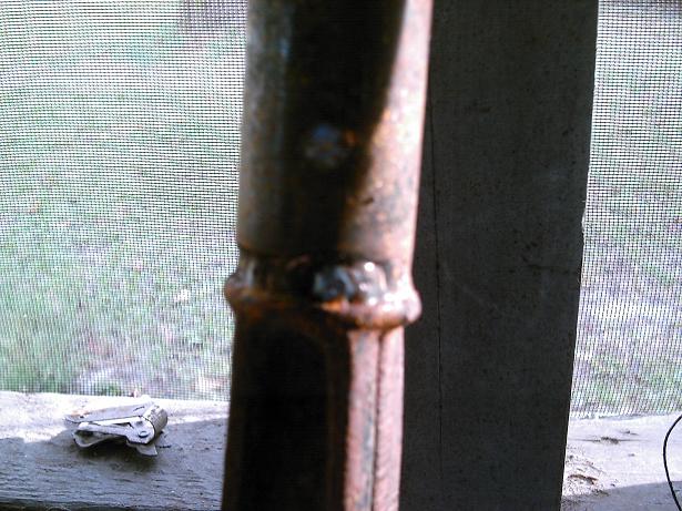 Rusted metal pole with visible weld marks