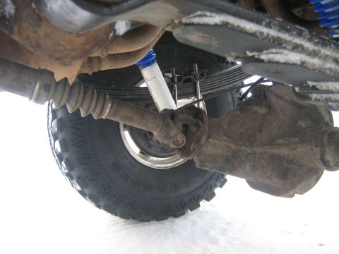 1995 Ford Bronco - Close-up of vehicle undercarriage components, including suspension and drivetrain parts.